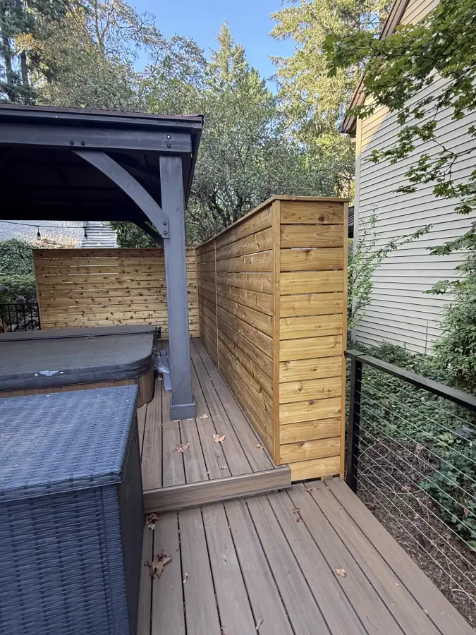 Custom composite deck, cedar privacy wall, and architectural cable railings by Rubi Construction LLC